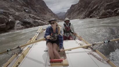 Woman rowing a wooden dory on the Colorado River in Grand Canyon