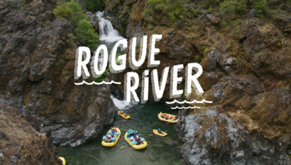 Waterfall on the Rogue River with a group of yellow rafts at its base