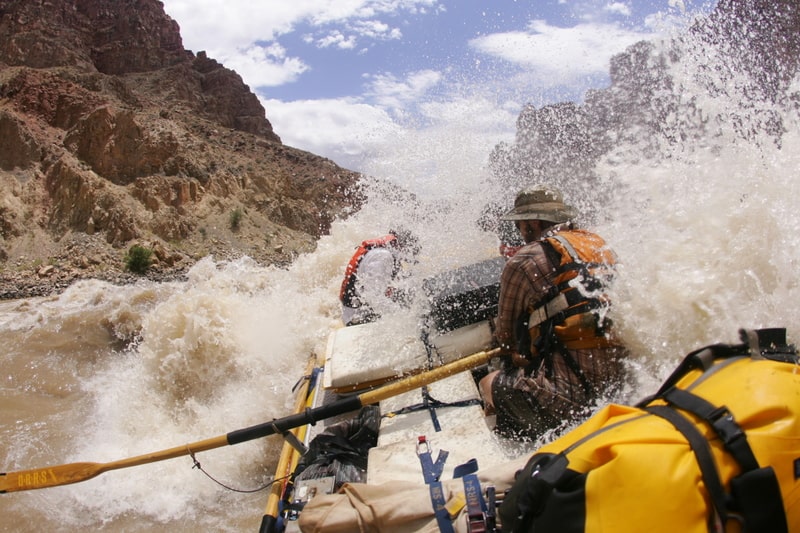 A raft splashed through a rapid in Cataract Canyon