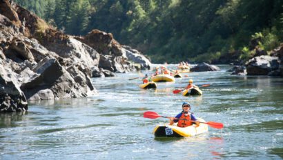 Multiple boats floating downstream on the Rogue River