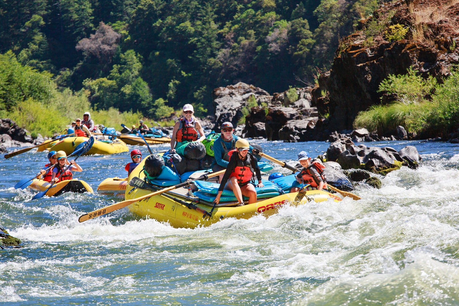 Oar rafts and inflatable kayaks tackle rapids on a family adventure down Oregon's Rogue River with OARS