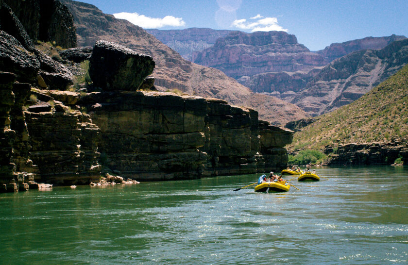 OARS rafts in green water of Colorado River in Grand Canyon