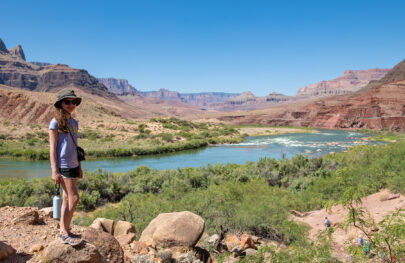 Girl poses for camera with tamarisk-lined Colorado River in background