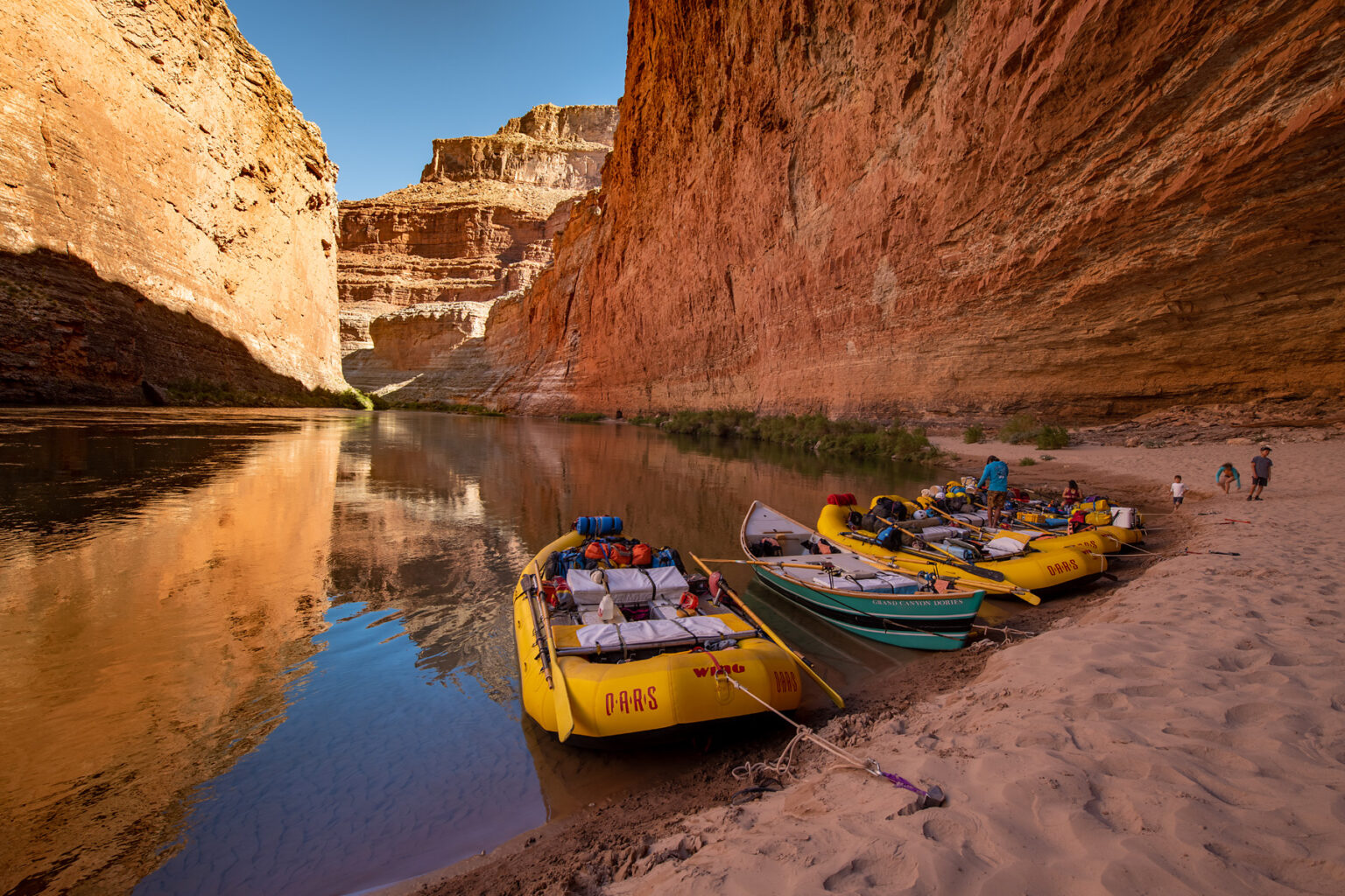 OARS rafts and dory moored at a sandy beach at the mouth of Redwall Cavern in Grand Canyon