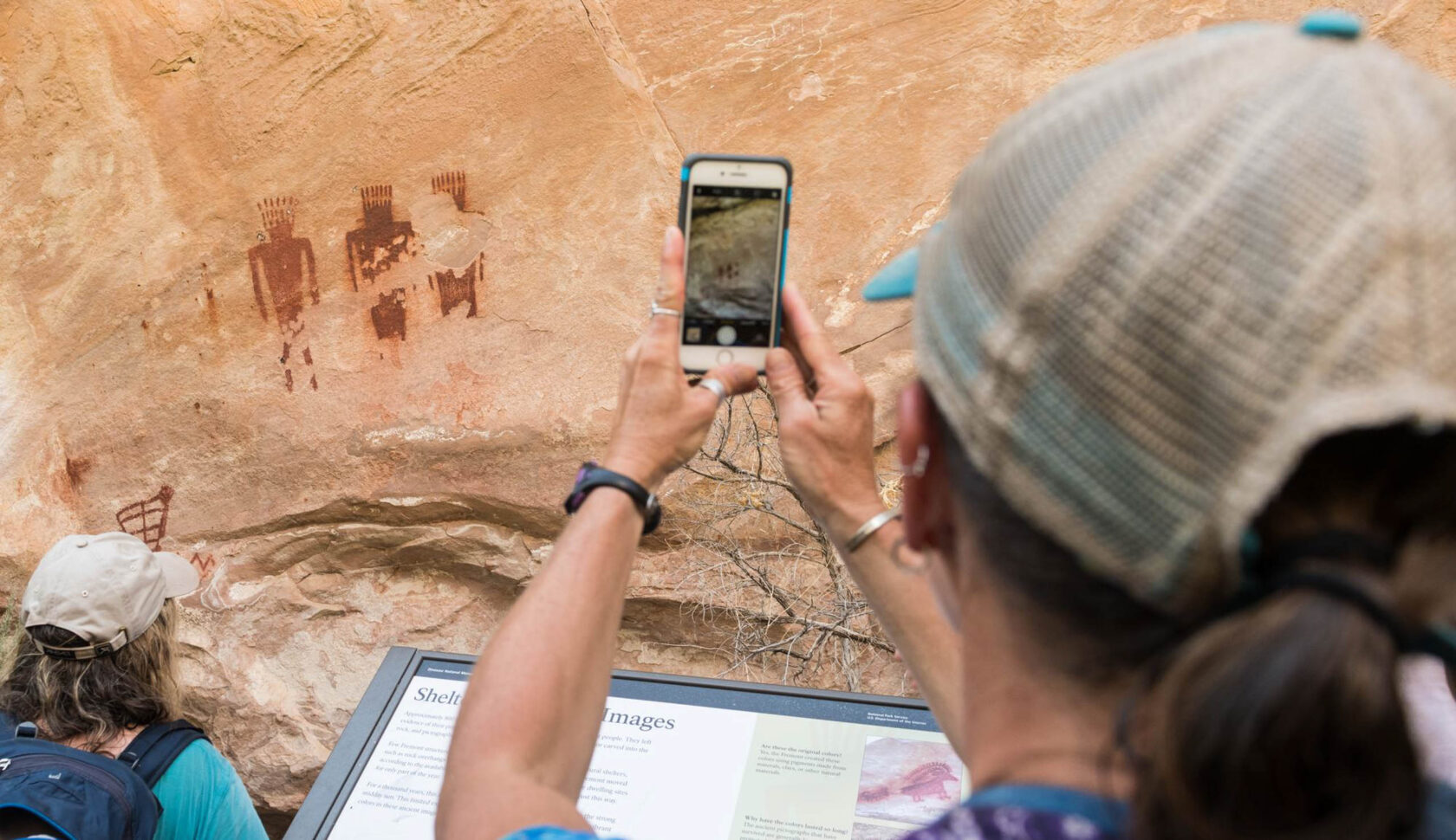 An OARS guest uses her smartphone to capture a photo of Native American rock art on a Gates of Lodore rafting trip.