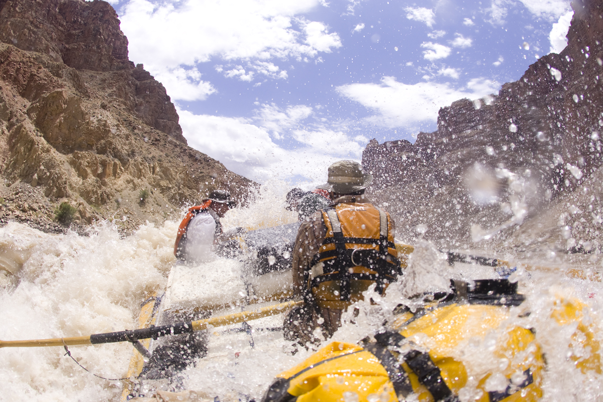 A guide rows guests on a Colorado River rafting through Cataract Canyon
