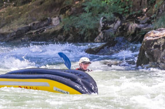Man in the rapids outside of his raft.
