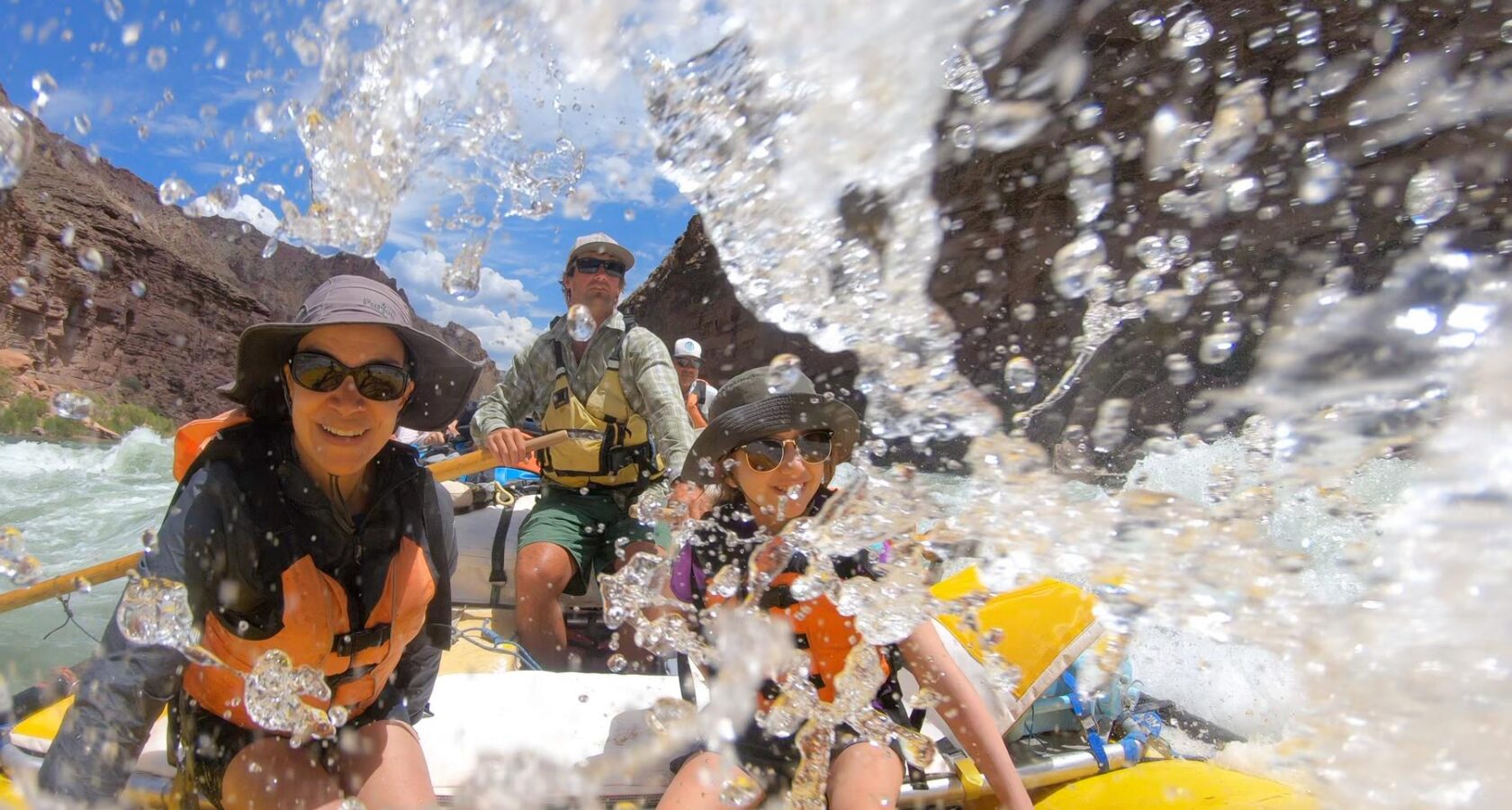 Rafters splashing through a rapid on a Grand Canyon rafting trip.