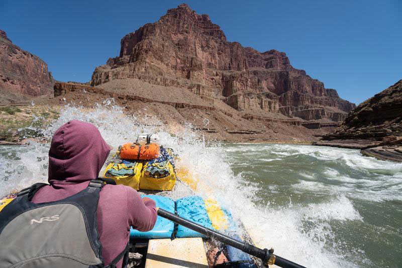 River guide running rapids in Grand Canyon