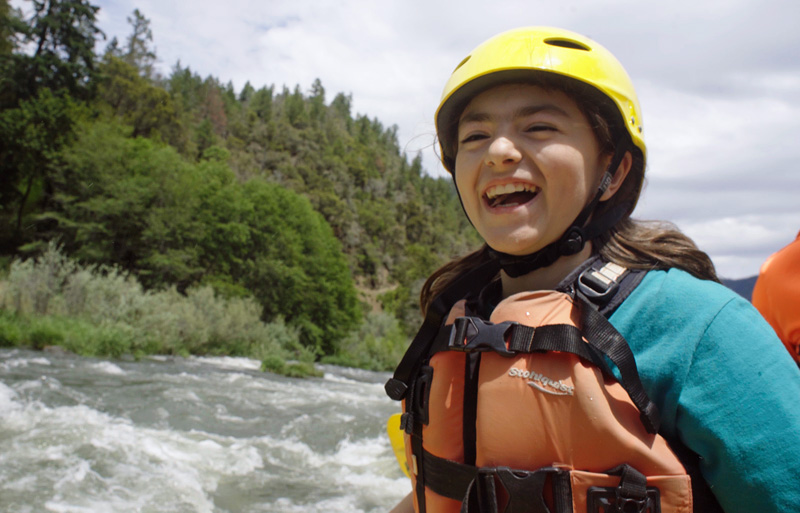 An excited paddler on a Rogue River rafting trip in Oregon