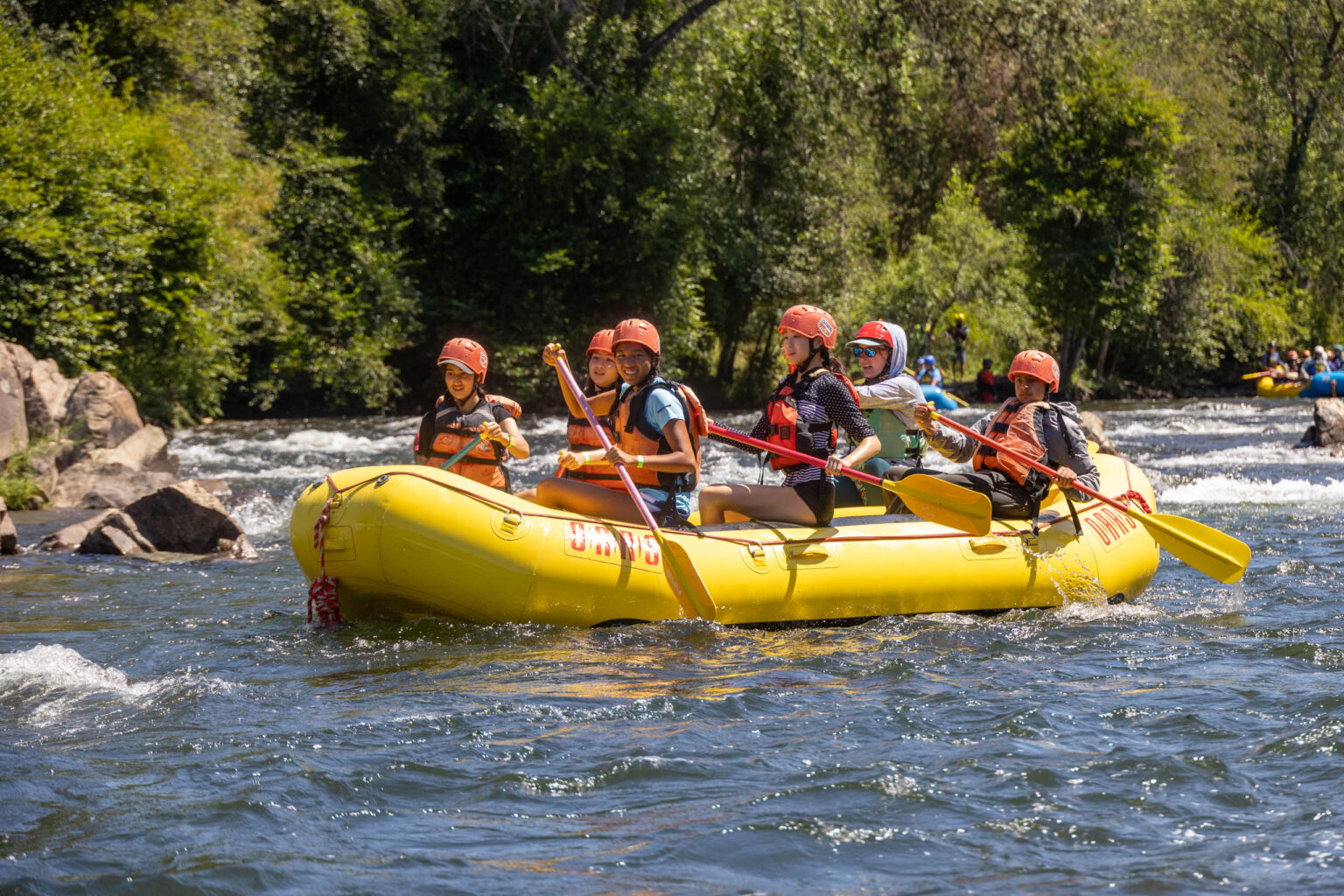Group of youth rafting down a river.