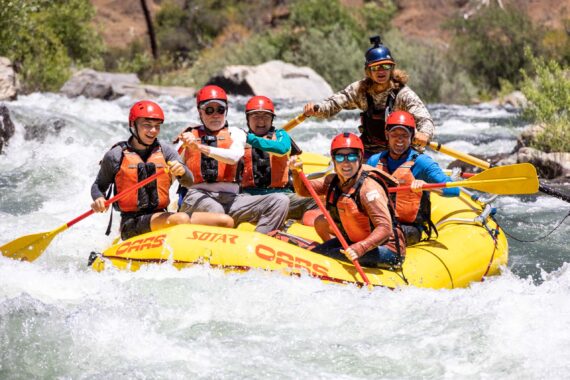 group of people in a raft in rapids.