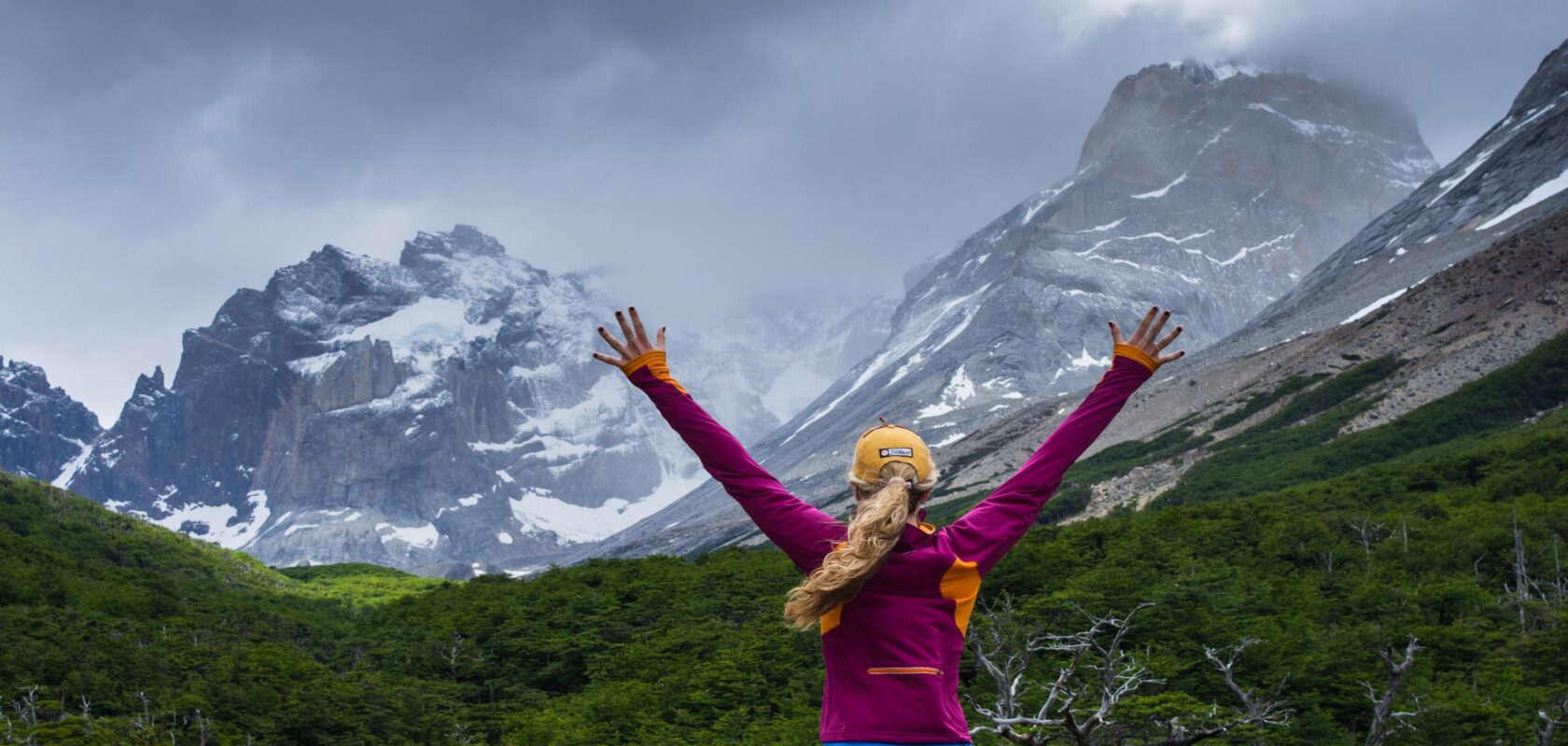 A hiker celebrates hiking the W Trek in Patagonia