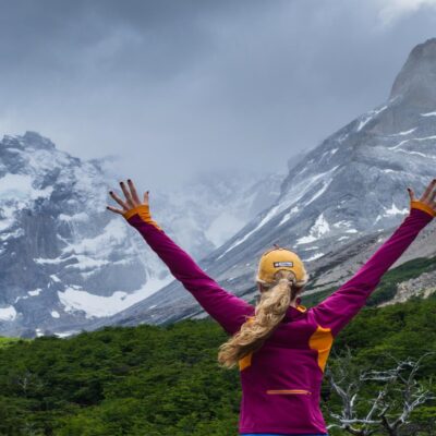A hiker celebrates hiking the W Trek in Patagonia