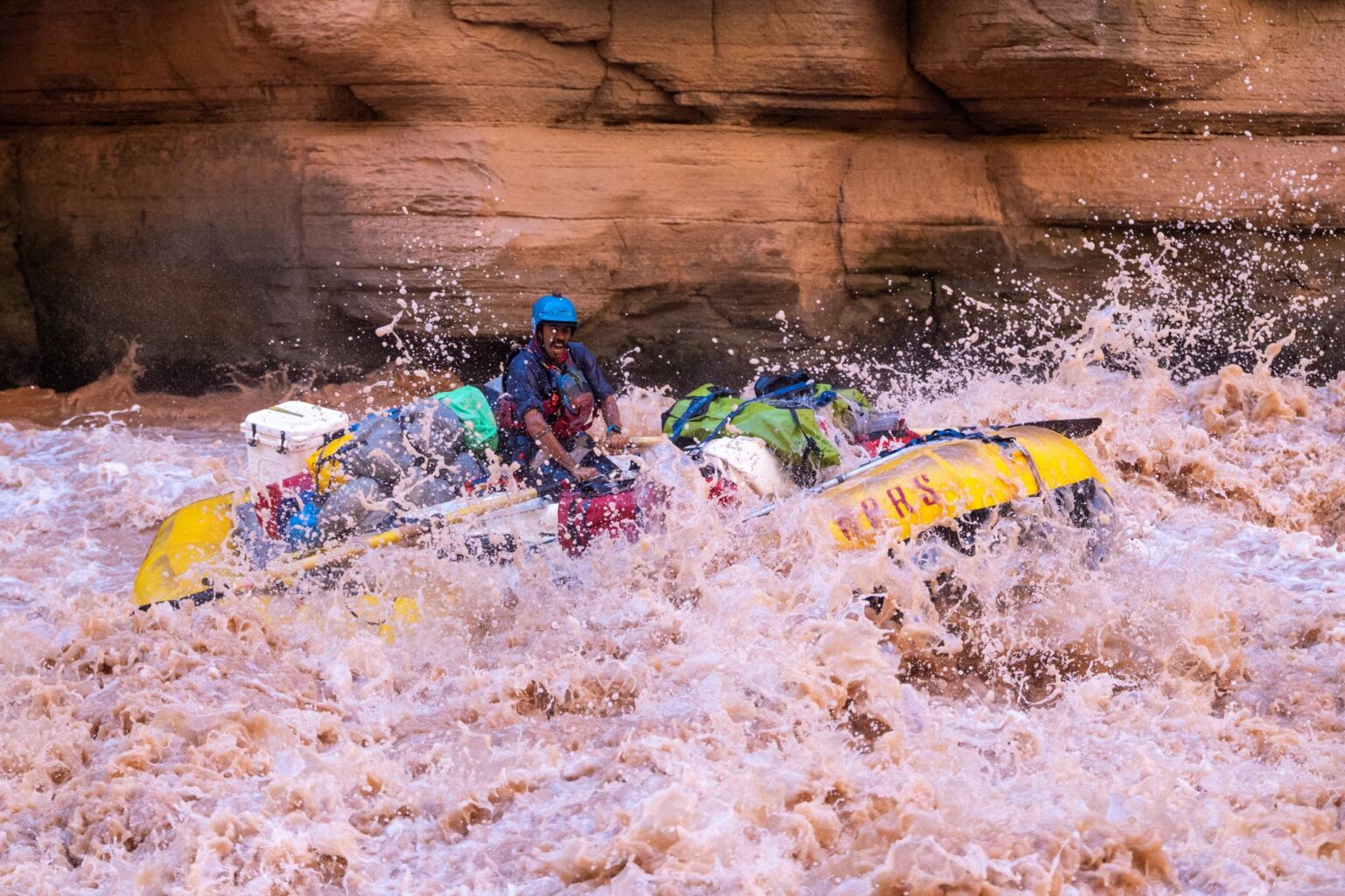 An OARS baggage raft running Upset Rapid in Grand Canyon