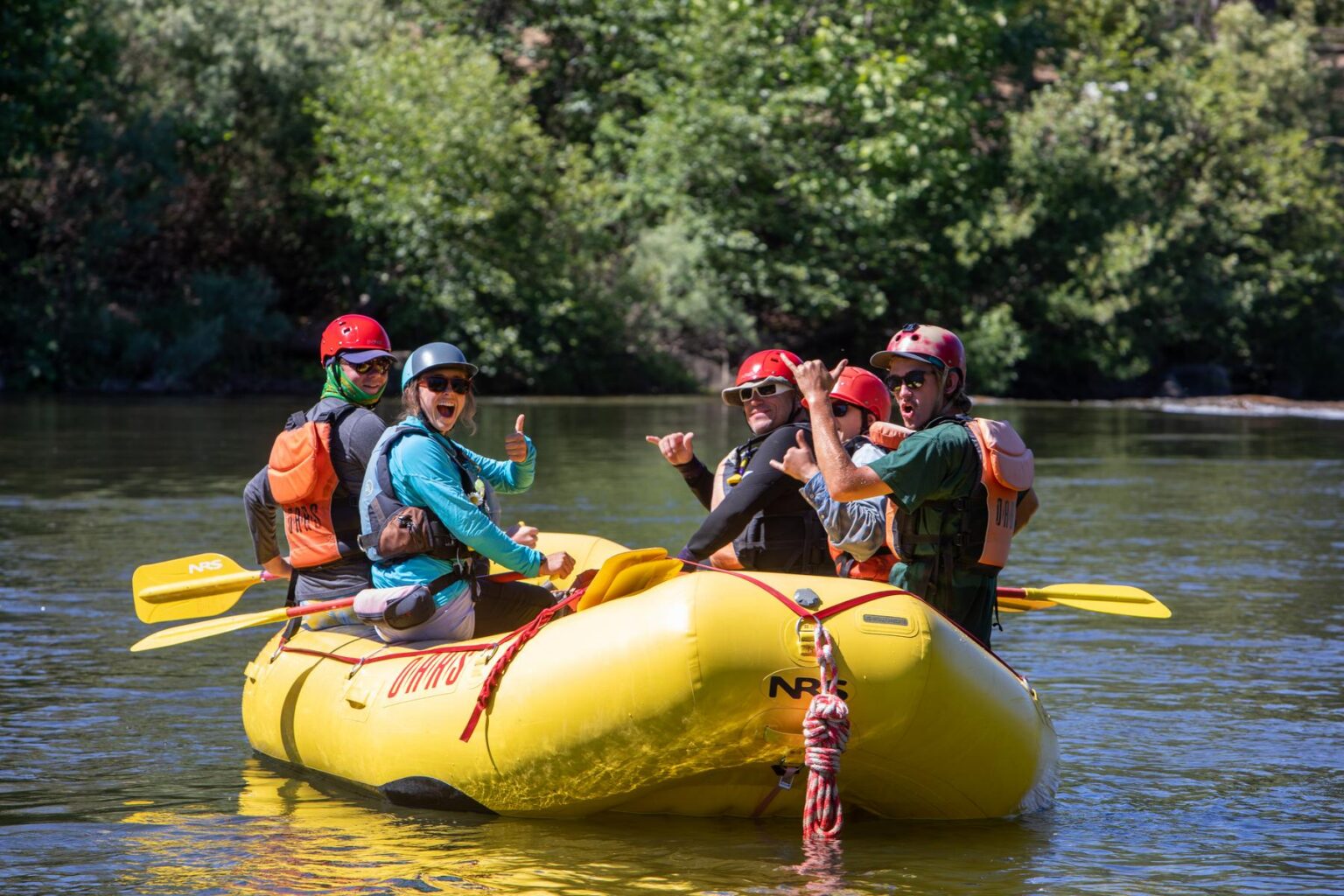 Group of paddlers giving the thumbs up on a calm stretch of the South Fork of the American River.