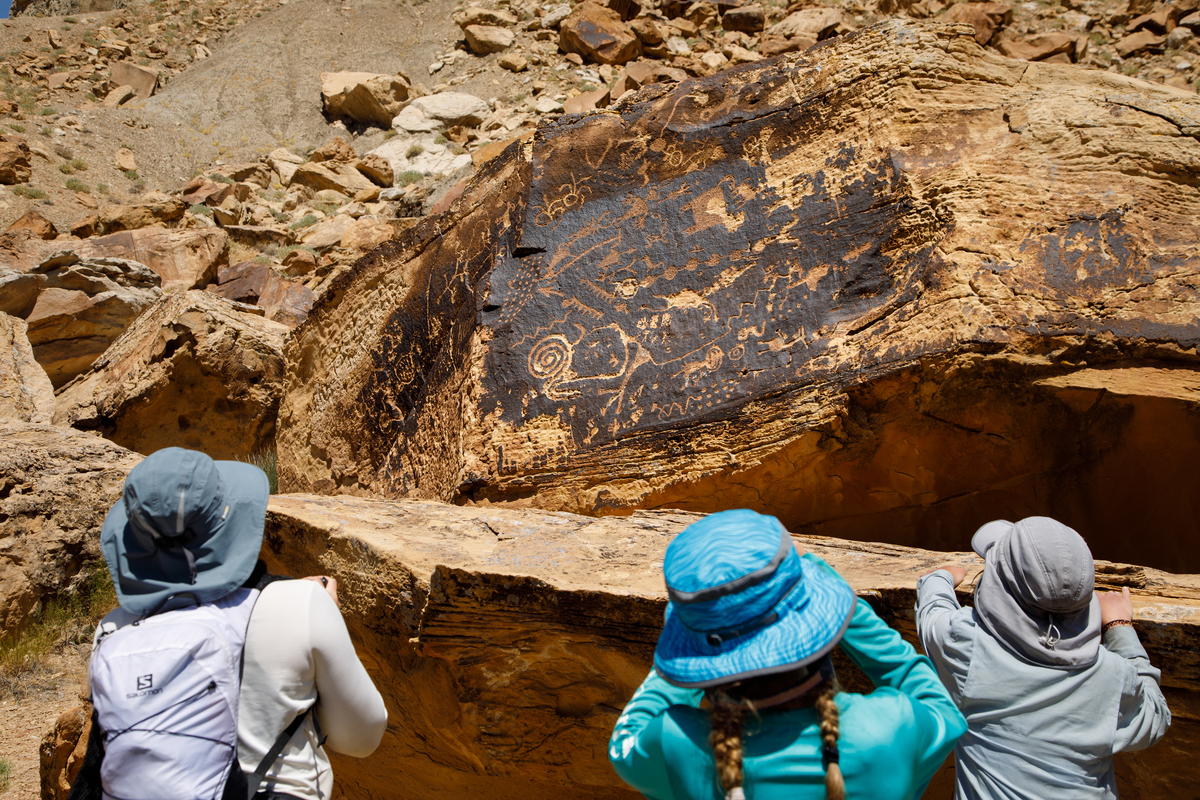 Hikers view petroglyps hidden along the Green River in Utah's Desolation Canyon